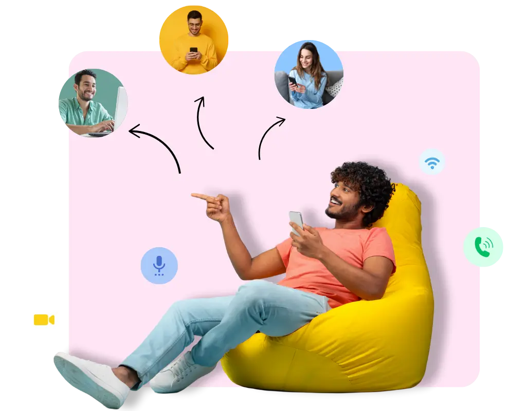A man sitting on a bean bag using a smartphone